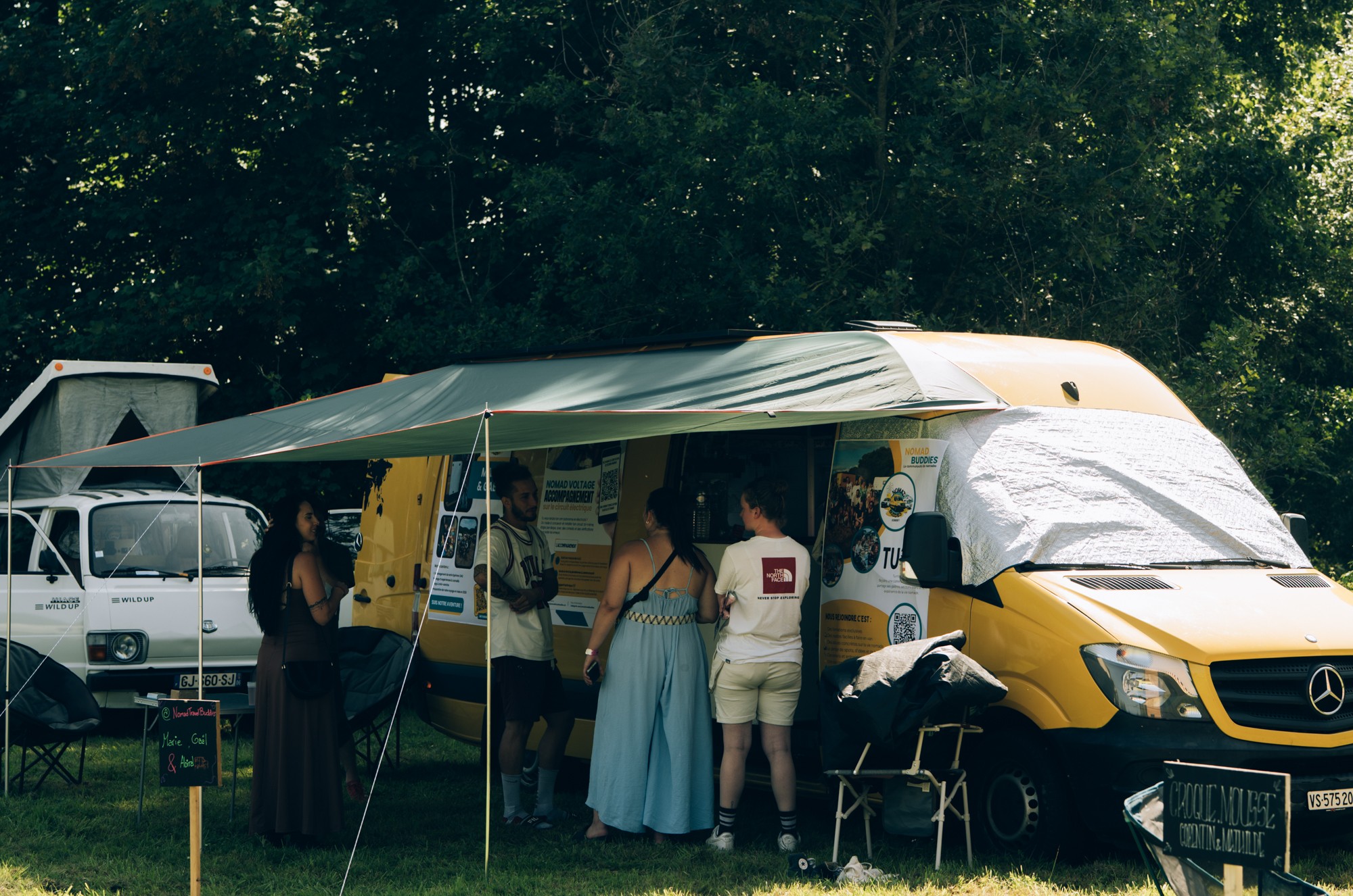 Le stand NomadTravelBuddies installé devant le van au Festivan