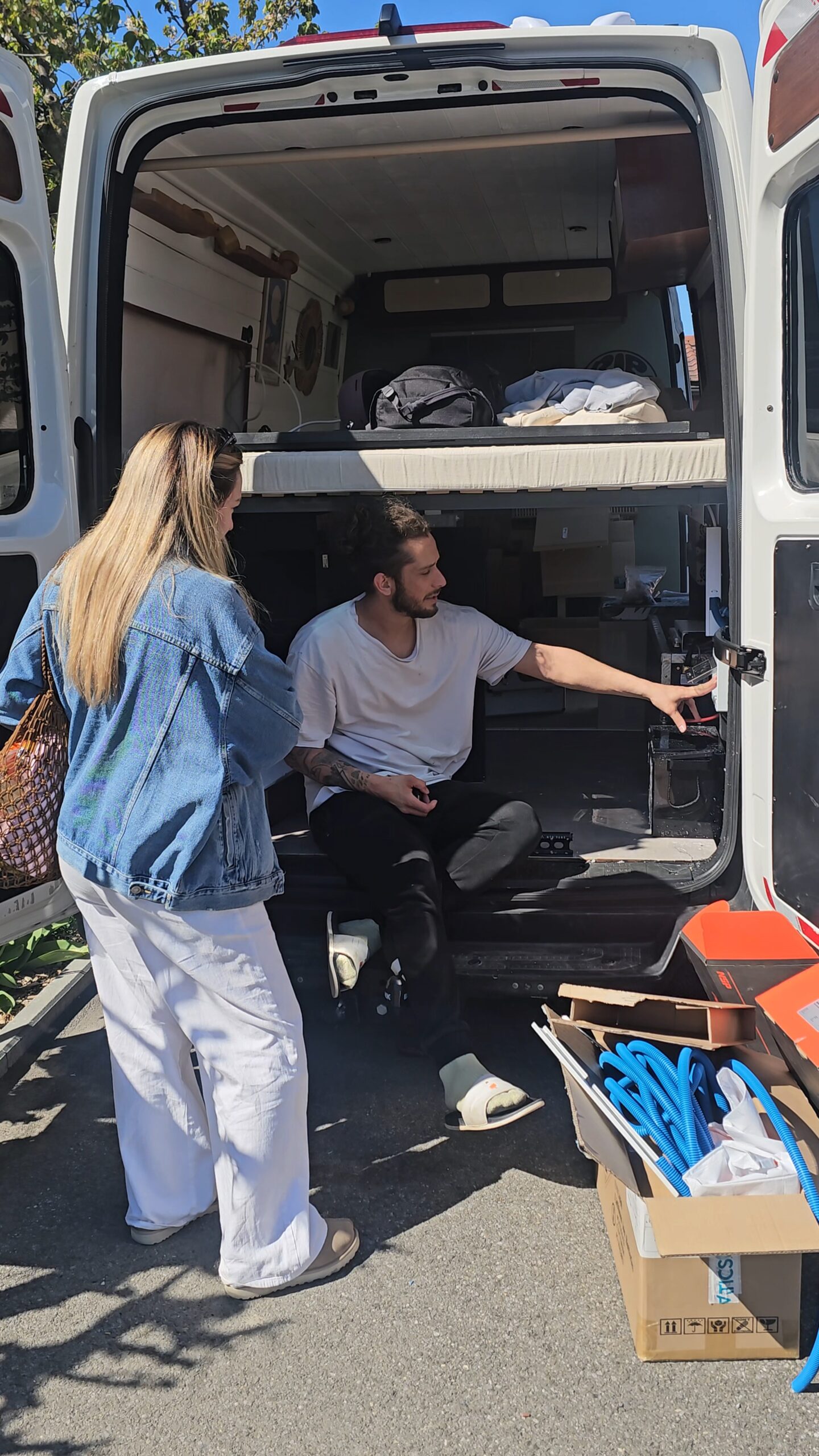 Gaël expliquant une installation électrique à l’arrière d’un fourgon aménagé