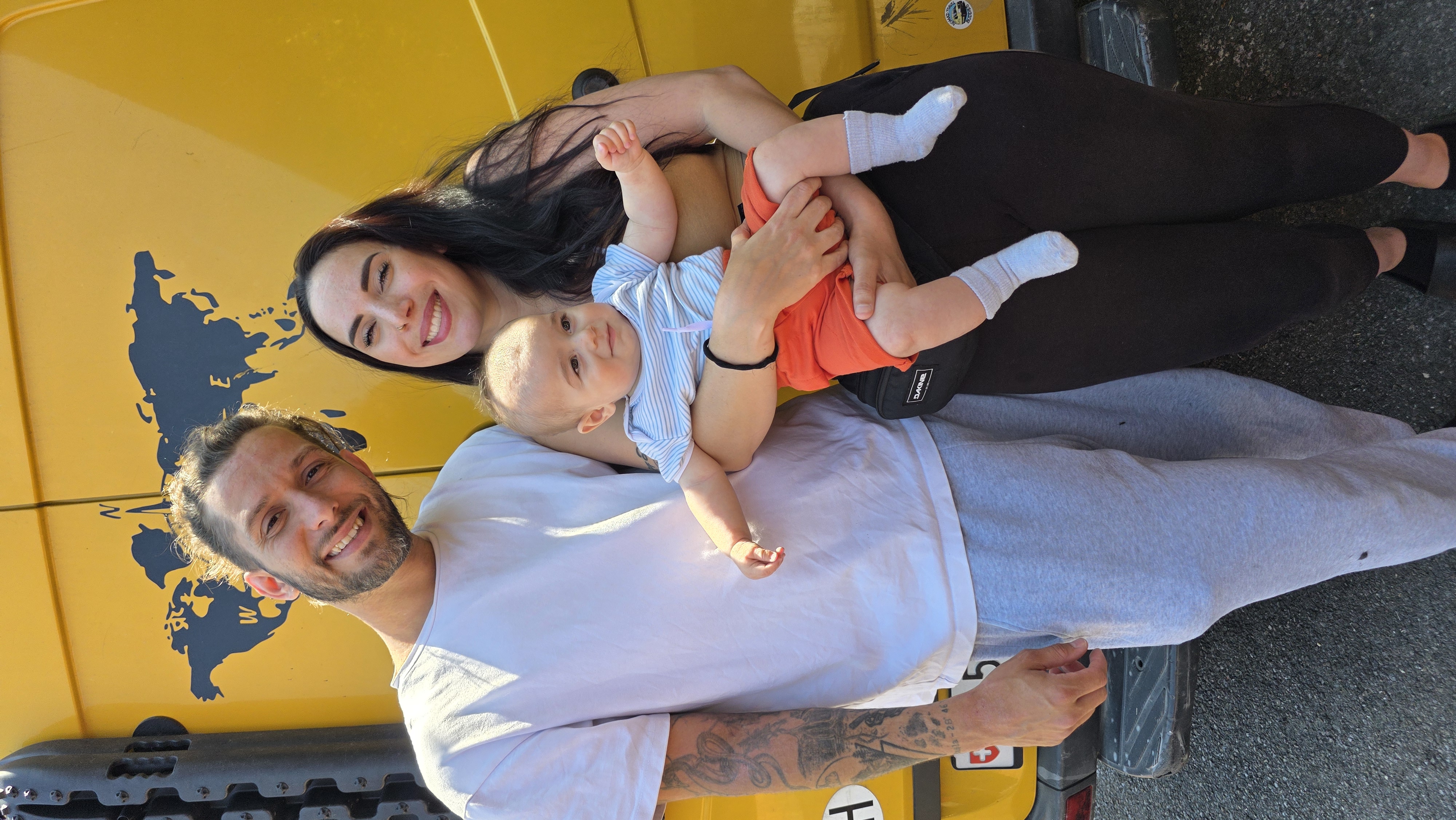Marie, Gaël et leur bébé Neo devant leur van jaune
